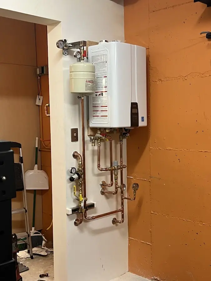 Plumbing technician inspecting water heater connections in Northlake